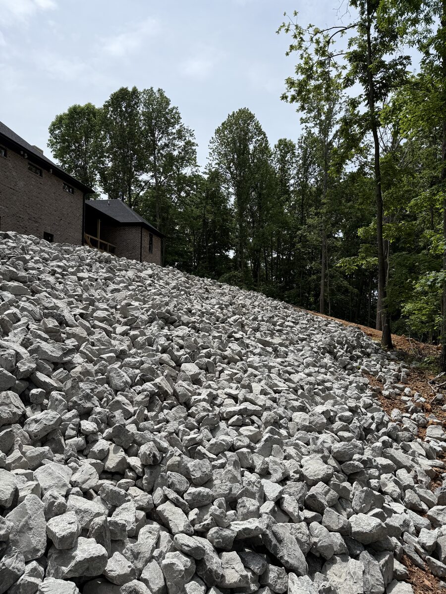 Massive riprap hillside erosion control installation next to home