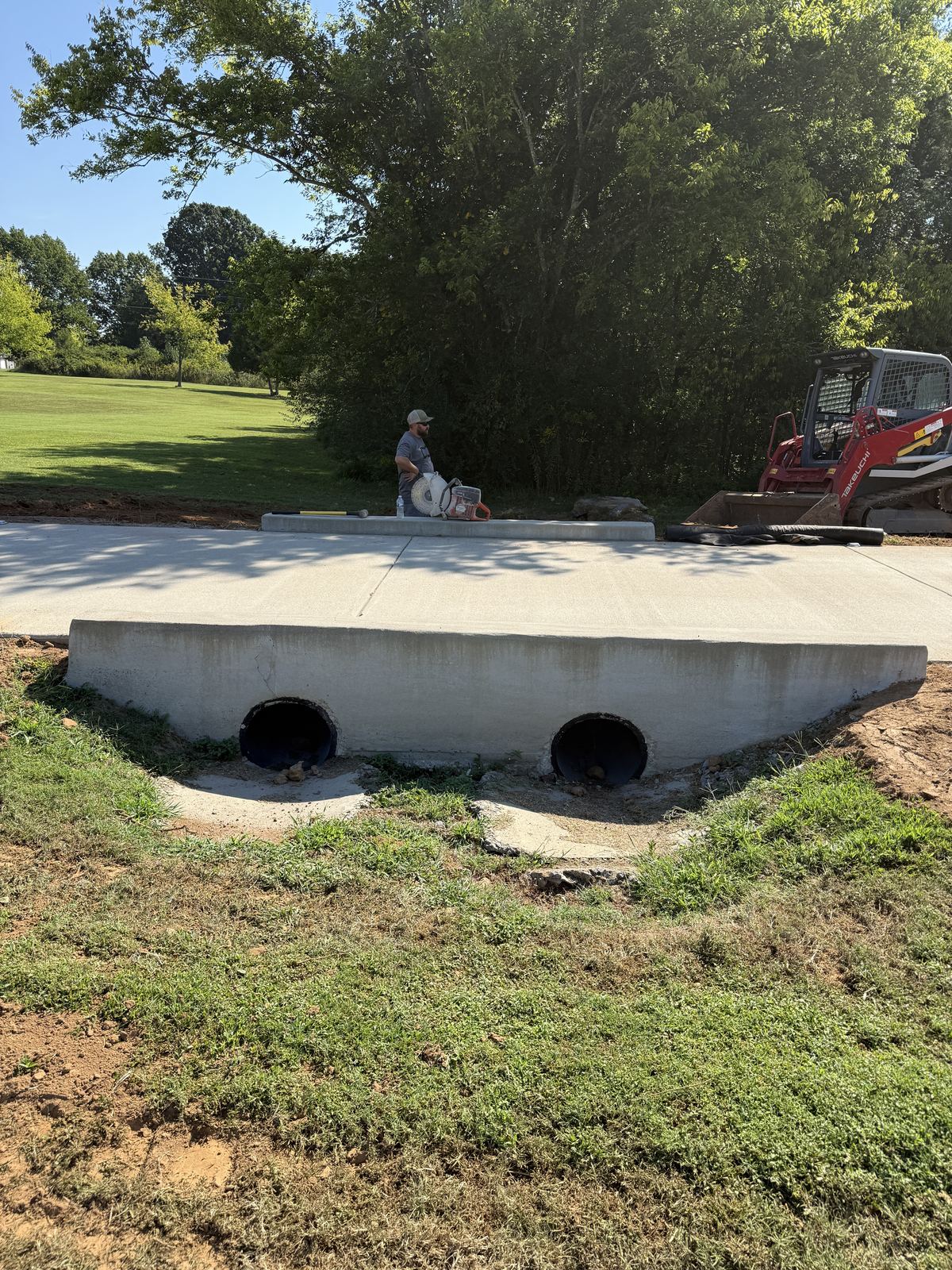 Poorly sloped concrete aprons poured at the outlets of twin driveway culvert pipes &mdash; Greenbrier TN, before removal