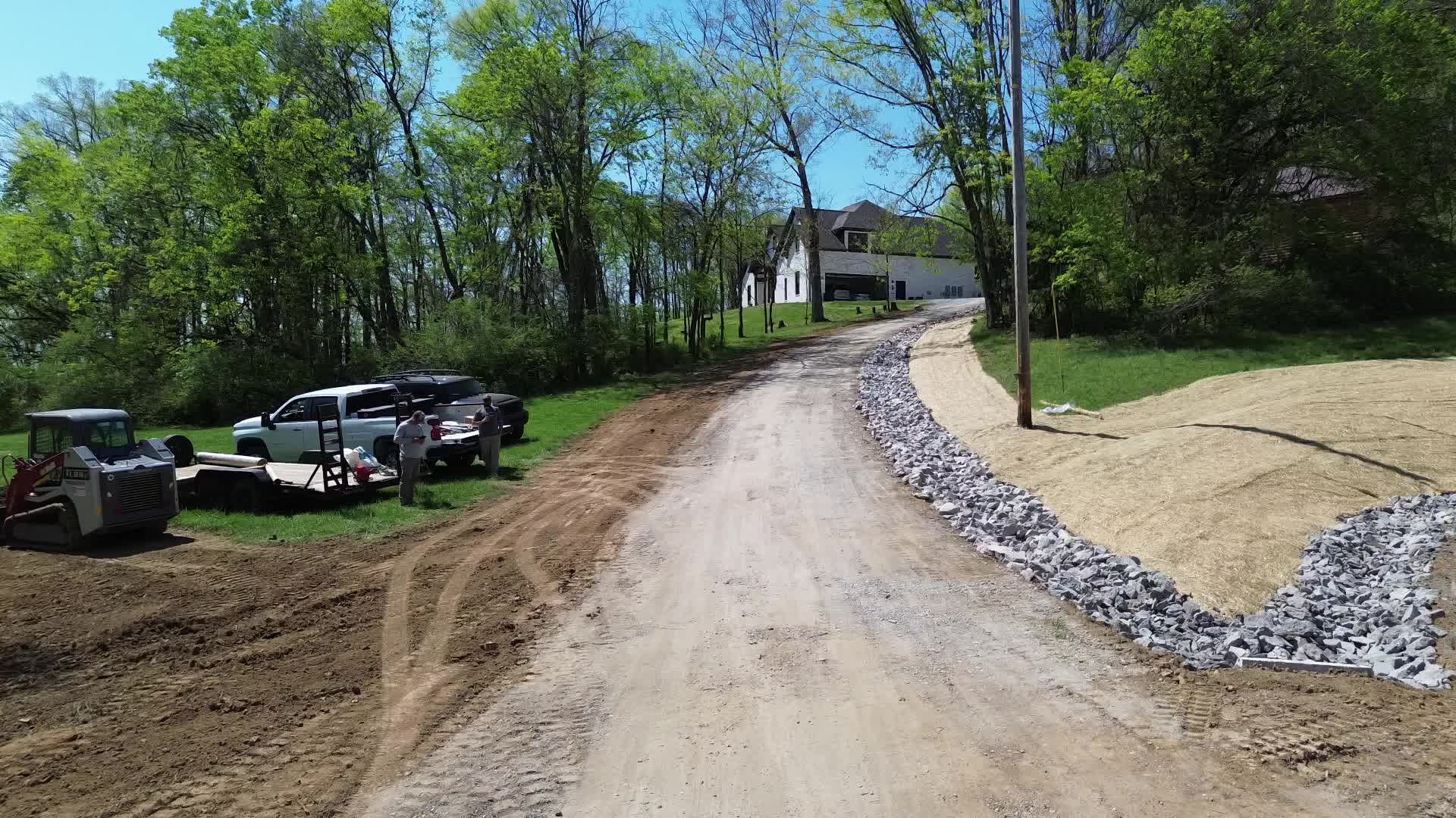 Aerial — gravel driveway installation with drainage channel
