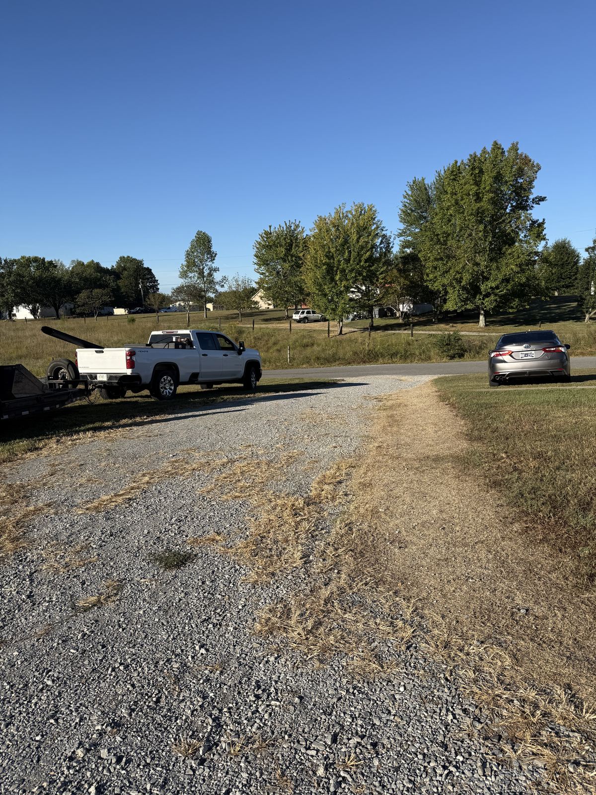 Gravel driveway thinned out with dead grass growing through the stone, looking toward the road &mdash; Cross Plains TN, before