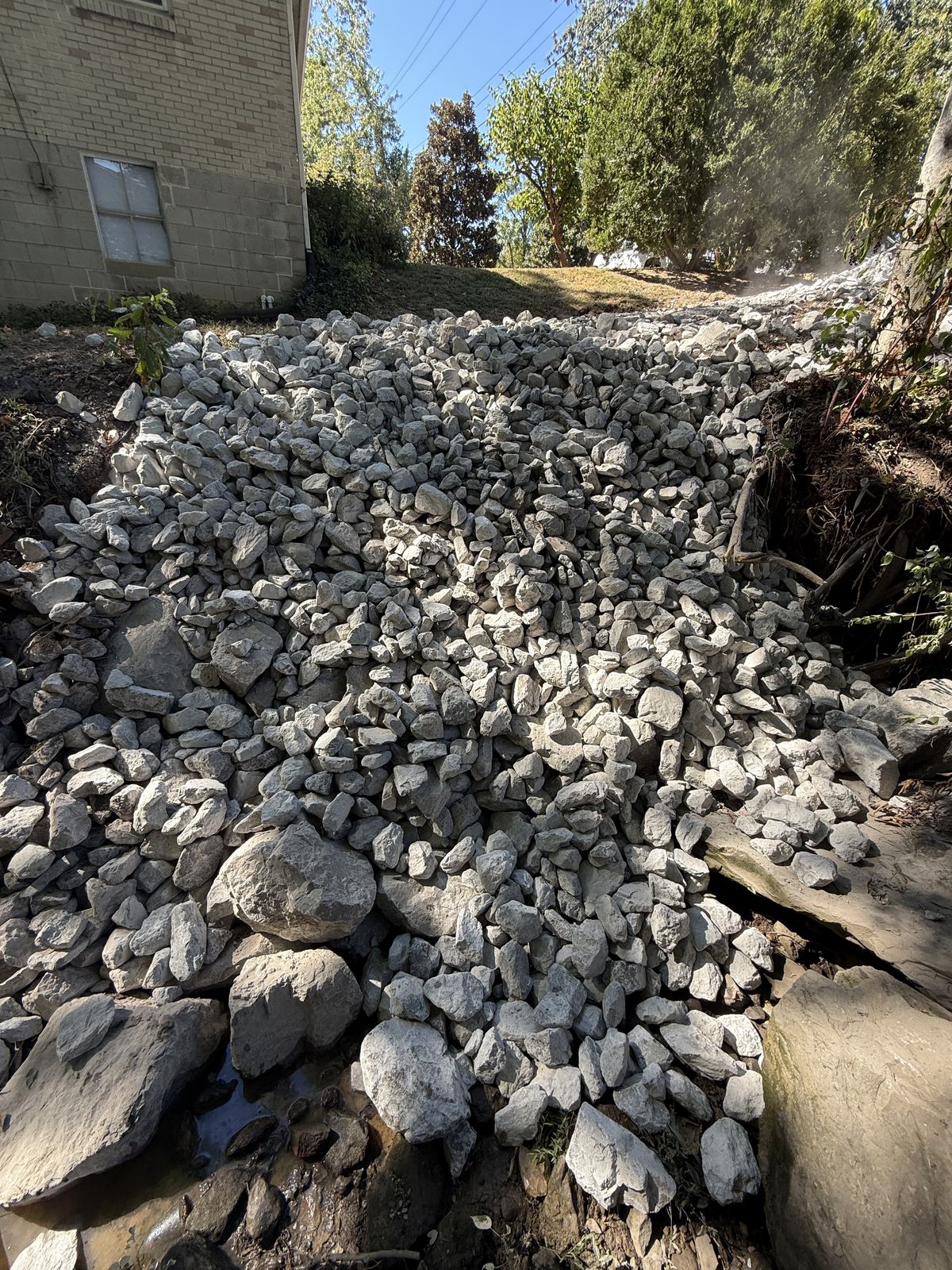Finished creek bank covered in Class A riprap over Class B, from the creek up to the yard &mdash; Nashville TN, after
