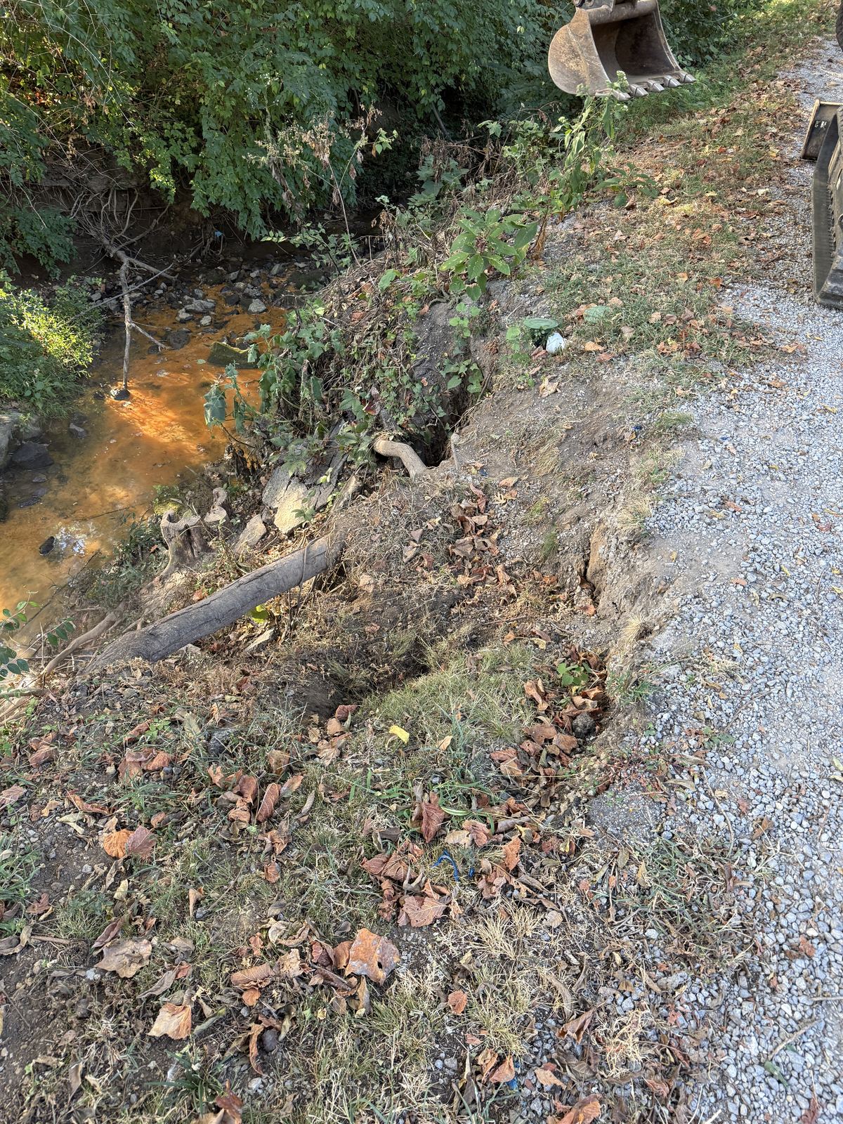 Eroded creek bank washing out at the edge of a gravel driveway, creek below &mdash; Nashville TN, before