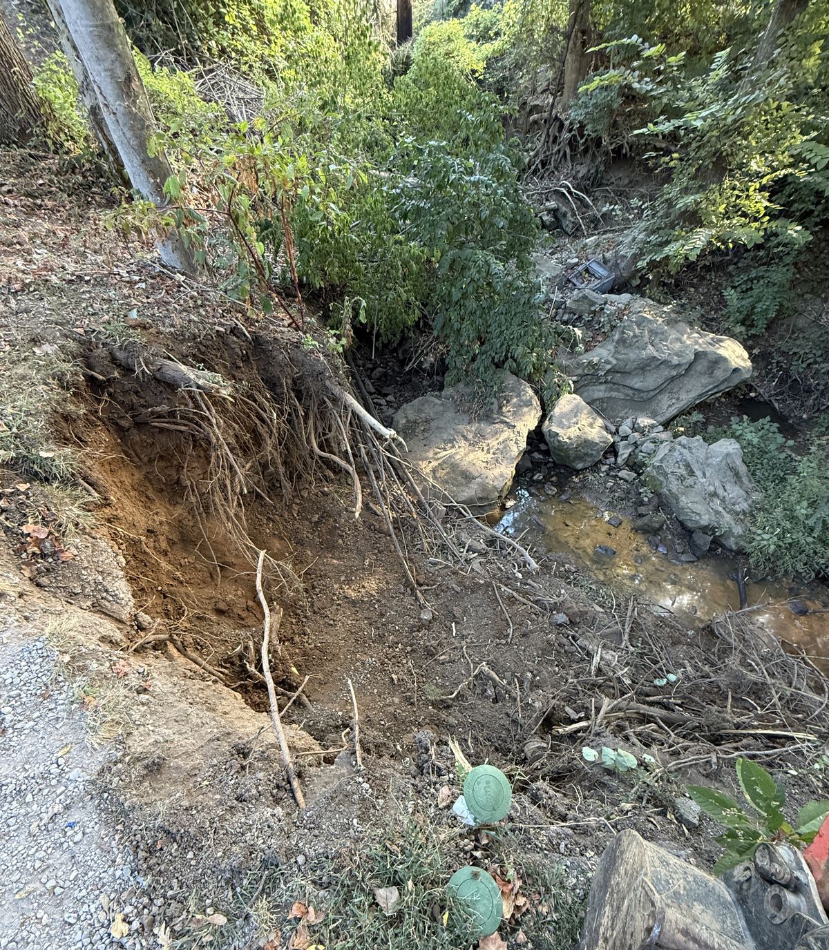 Washed-out creek bank opened up and cleaned out down to firm ground before riprap &mdash; Nashville TN
