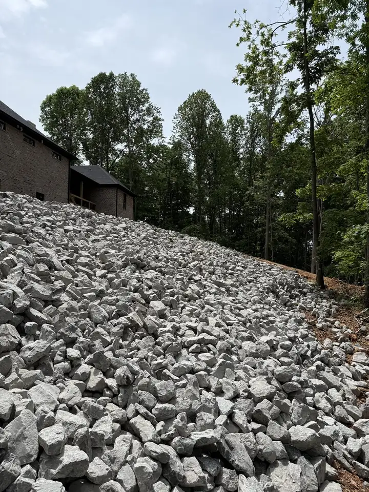 Massive riprap hillside erosion control installation next to home