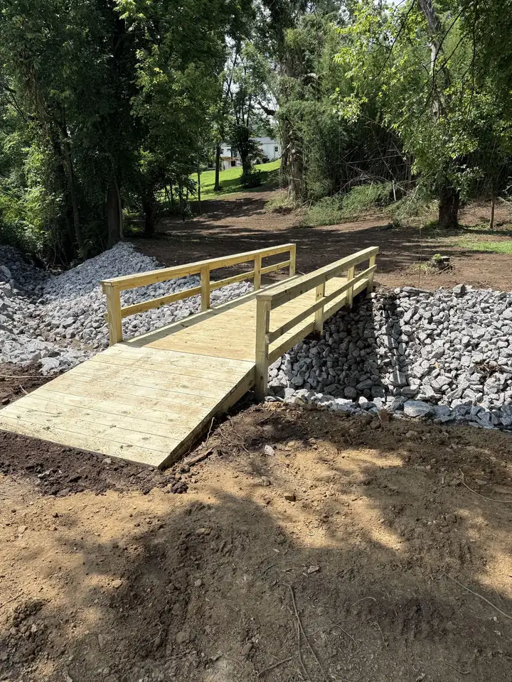 Ground-level view — completed bridge over riprap erosion control channel
