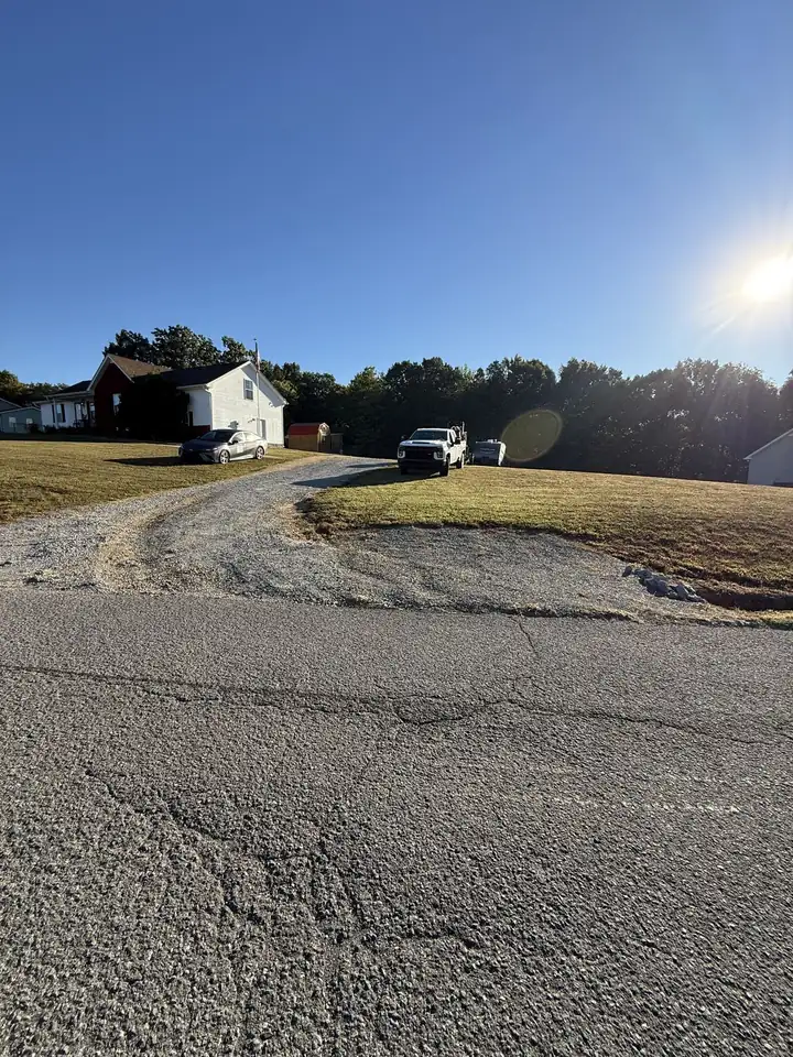 Worn gravel driveway apron with ruts and grass before rebuild — Cross Plains TN